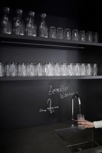 a row of wine glasses on a shelf above a sink at Carina - Design&Lifestyle hotel in Zermatt