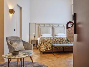 a bedroom with a bed and a chair and a table at Classik Hotel Alexander Plaza in Berlin