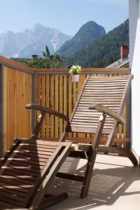 un banco de madera sentado en una terraza con montañas al fondo en Apartments Katja, en Kranjska Gora