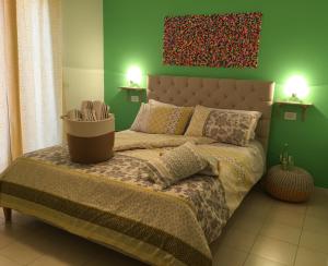 1 dormitorio con 1 cama con pared verde en Intra Rooms, en Olbia