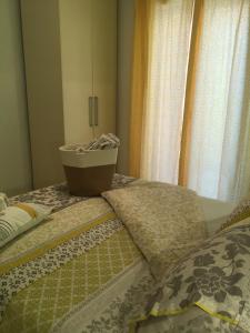 1 dormitorio con 2 camas, cortinas y cesta en Intra Rooms, en Olbia