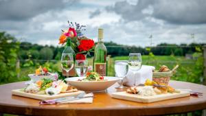 a table with plates of food and a bottle of wine at Gästehaus Ranftl in Unterlamm