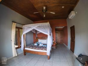 una camera con letto a baldacchino di Anugerah Villas ad Amed