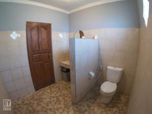 bagno con servizi igienici e porta in legno di Anugerah Villas ad Amed