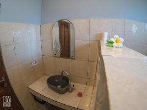 bagno con lavandino e specchio di Anugerah Villas ad Amed