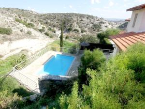 una piscina in mezzo a una collina con una casa di Amoroza Villa a Pissouri