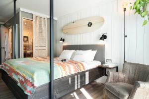 una camera con letto e tavola da surf sul muro di Beach Motel St. Peter-Ording a Sankt Peter-Ording