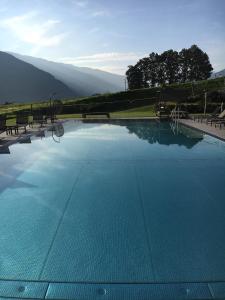 uma grande piscina com bancos e montanhas ao fundo em Hotel Elisabeth em Fügen