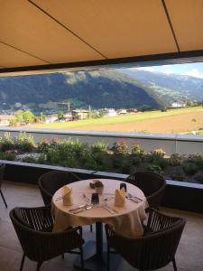 uma sala de jantar com mesa e cadeiras e uma grande janela em Hotel Elisabeth em Fügen