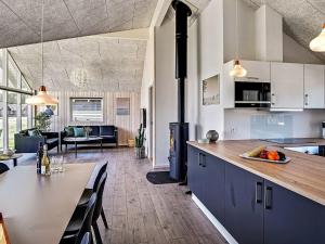 a kitchen and living room with a table and a stove at 12 person holiday home in Hasselberg in Kappeln