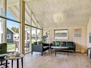 a living room with couches and tables and windows at 12 person holiday home in Hasselberg in Kappeln