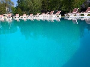 a group of chairs sitting in a pool of blue water at База відпочинку "РіверСайд" СВІТЛО Є ЗАВЖДИ in Novomoskovsʼk