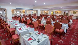 een feestzaal met witte tafels en stoelen bij Barrowfield Hotel in Newquay