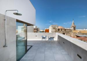 een balkon met een tafel en stoelen op een dak bij Dormos Hotel in Cádiz