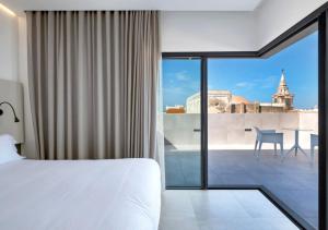 een slaapkamer met een bed en uitzicht op de stad bij Dormos Hotel in Cádiz