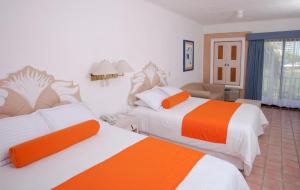 a hotel room with two beds with orange and white at Flamingo Vallarta Hotel & Marina in Puerto Vallarta