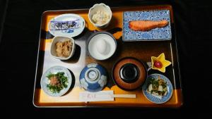 uma bandeja com pratos de comida numa mesa em Hotel New Mogamiya em Yamagata