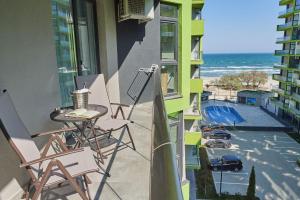 - un balcon avec une table et des chaises et la plage dans l'établissement Sea Love apt SPA n Pools Beach Resort, à Mamaia Nord – Năvodari