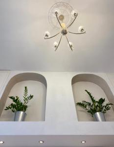 um tecto com um candelabro e dois vasos com plantas em Domus Valadier B&B Guesthouse em Fiumicino