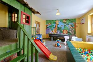 - une salle pour enfants avec une aire de jeux dotée d'un toboggan dans l'établissement Góralski Gościniec & SPA, à Poronin