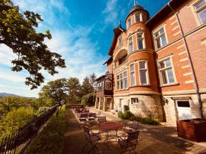 a building with tables and chairs in front of it at Hotel Villa Viktoria Luise in Blankenburg