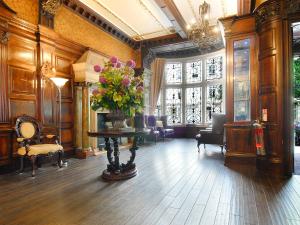 um lobby com um vaso de flores sobre uma mesa em Grand Royale Hyde Park em Londres