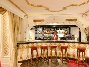 um bar num hotel com bancos vermelhos em Grand Royale Hyde Park em Londres