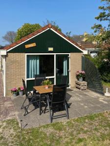 une terrasse avec une table et des chaises devant une maison dans l'établissement Anna, à Hollum