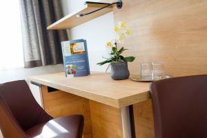 une table avec un livre et un vase de fleurs sur elle dans l'établissement Hotel Stich, à Manhartsbrunn