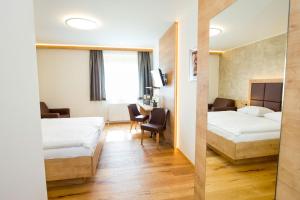 Cette chambre comprend deux lits et un bureau. dans l'établissement Hotel Stich, à Manhartsbrunn