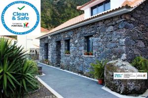 una casa de piedra con un cartel que dice limpio y seguro en Cottage Quinze, Contemporary designed cottage with Swimming pool, en Ponta Delgada