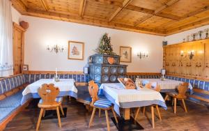 comedor con 2 mesas y sillas y techos de madera en Hotel Sporthof Austria, en Ramsau am Dachstein