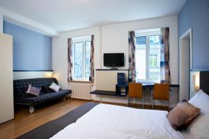 1 dormitorio con 1 cama y escritorio con TV en Hotel Bristol Zurich, en Zúrich