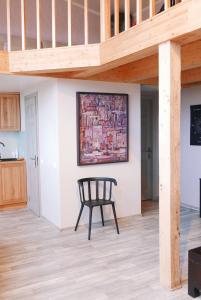 a wooden chair in a living room with a staircase at Artists Residence Liepāja in Liepāja