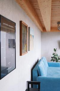 a living room with a blue couch and a tv at Artists Residence Liepāja in Liepāja