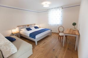 1 dormitorio con cama, mesa y sofá en Casa Krasna Gourmet Boutique Hotel, en Lokev