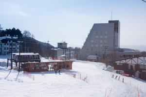 una pista de esquí en una ciudad con gente en ella en Takamiya Hotel Rurikura Resort, en Zao Onsen