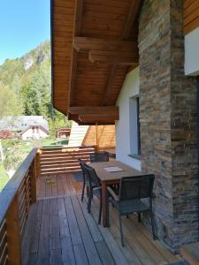 een houten terras met een tafel en stoelen erop bij Hiša Katja-Privat wellness in Kranjska Gora