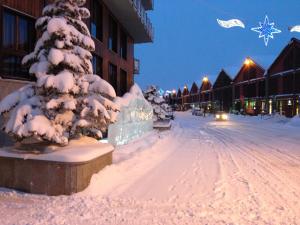 a snow covered christmas tree on a city street at Hotel Cristallo in Sestriere