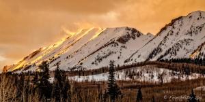 a snow covered mountain with trees in front of it at Alpine Inn & Suites Gunnison in Gunnison