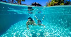 Dos mujeres están nadando en una piscina en Lakeside Forster Holiday Park and Village, en Forster