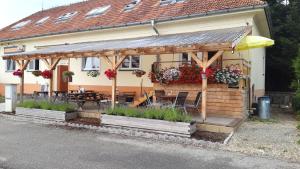 een huis met een houten pergola met een tafel en stoelen bij Penzion-Na Navsi in Horní Planá