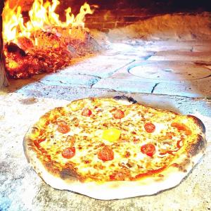 une pizza est assise dans un four à feu dans l'établissement Auberge de Thelis, à Thélis-la-Combe