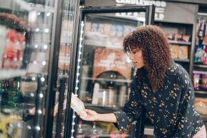 une femme debout dans un magasin à la recherche d'un réfrigérateur dans l'établissement Candlewood Suites Boise-Meridian, an IHG Hotel, à Meridian