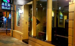 a store front with columns on a street at night at Sur Hotel in Montevideo