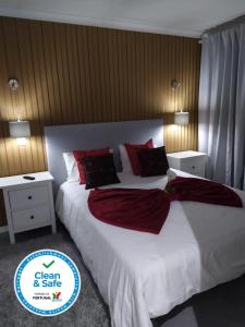 a bedroom with a large white bed with red pillows at Casa da Leninha in Nazaré