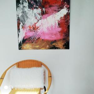 a painting hanging on a wall next to a chair at L'adresse à Besançon in Besançon