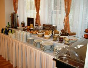 een buffet met borden en eten op tafel bij Hotel Garni Rambousek in Praag