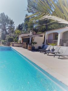 einen Pool mit Stühlen und ein Haus in der Unterkunft Villa Manoe in Draguignan