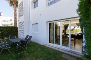 d'une terrasse avec une table et des chaises dans la cour. dans l'établissement Ground Floor with private garden Bellresguard, à Port de Pollença